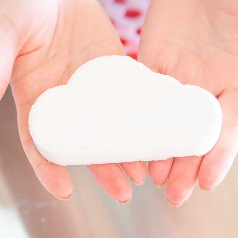 Two hands holding a white cloud bath bomb