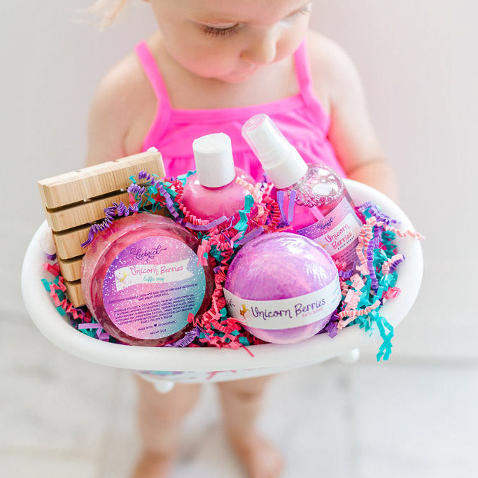 Little girl showing a personalized unicorn bath product gift set